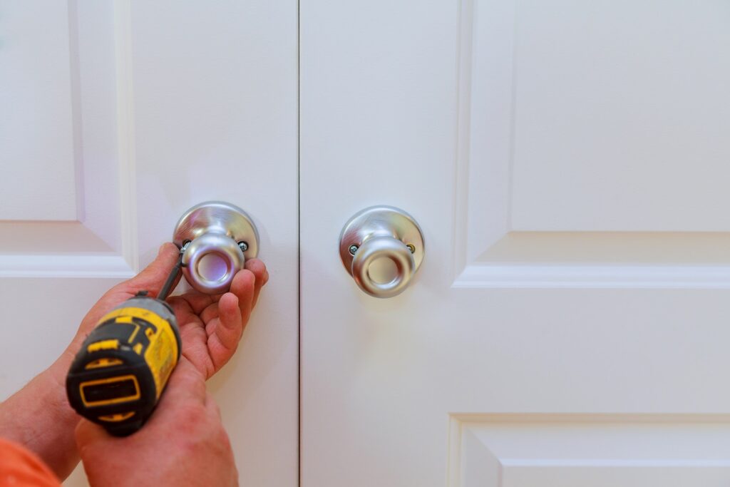 Sliding Door knobs, aluminum door white background. installation of a lock at the door